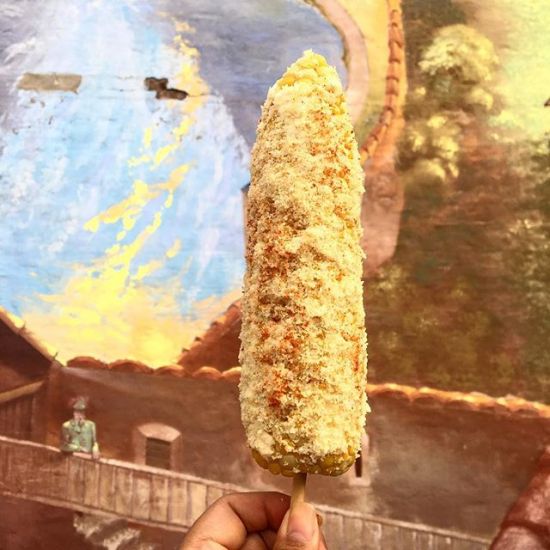 Truth: I go to farmer’s markets for the food. Elotes blending into the mural. 